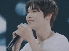 a man is singing into a microphone and smiling