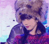a woman wearing a fur hat and a necklace is looking at the camera