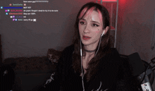 a girl with pink hair and ear buds is smiling while watching a video