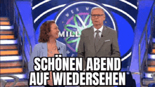 a man and a woman are standing on a stage in front of a wheel of fortune on a game show .