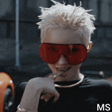 a woman wearing a black shirt and red sunglasses with the letters ms on the bottom