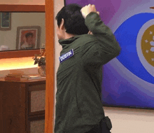 a man in a green jacket with dustin written on his back