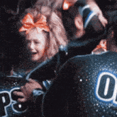 a cheerleader with a bow on her head and the number 0 on her back is crying