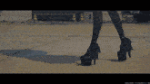 a woman wearing a pair of high heels is walking on a sidewalk