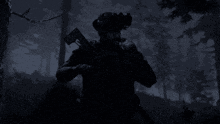 a man holding a gun in a dark forest with trees in the background