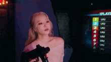 a woman is holding a gun in front of a sign that says 1 through 7