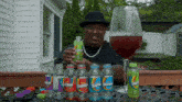 a man is holding a bottle of skittles in front of a large glass