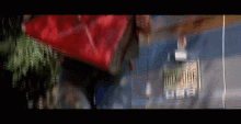a person carrying a large red bag with a license plate that says box 006