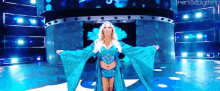 a woman in a blue robe is standing on a stage