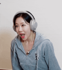 a woman wearing headphones and a hoodie with a letter b on it