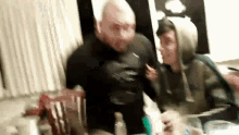 a man and a boy are standing next to each other in a room .