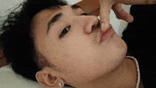 a close up of a person 's face with a pearl necklace on
