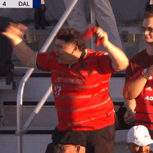 a man wearing a red shirt with the number 17 on it is cheering