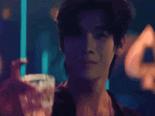 a man is holding a glass of whiskey in his hand .