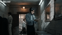 a man in a suit and tie is standing in a bathroom next to a mirror .