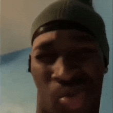 a close up of a man wearing a beanie and ear buds .