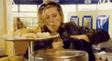a woman is sitting at a table with a tray of food on it .