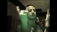 a man in a dark room with a green light shining on his face