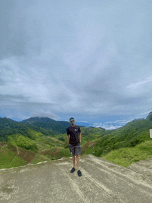 a man wearing a t-shirt that says ' abercrombie & fitch ' on it stands on a dirt road