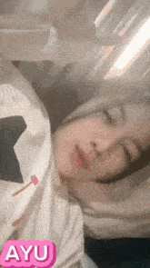 a girl is laying in bed with a sticker that says ayu on it