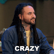 a man with dreadlocks and a beard has the word crazy above his head