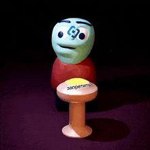 a cartoon character is sitting at a table with a yellow button that says " запретить "