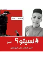 a picture of a man in a red jacket with arabic writing behind him