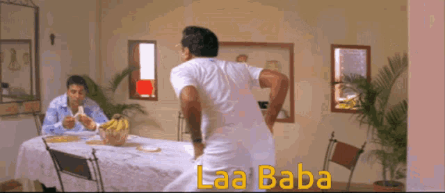 a man in a white shirt is standing in front of a table with the word laa baba written on it