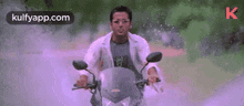 a man is riding a motorcycle on a dirt road in a movie .