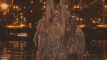 a group of people are dancing on a stage with a lot of lights .