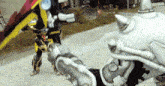 a man in a black and yellow costume is fighting a robot with a sword .