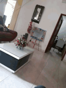 a vase of flowers sits on a white table in a living room