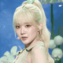 a blonde woman with a green bow in her hair