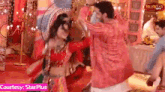 a man and a woman are dancing together in a room with a sign that says courtesy : starplus .