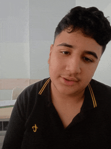 a young man wearing a black shirt with the letter j on the front
