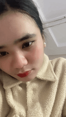 a close up of a woman 's face with a white shirt on