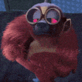 a stuffed animal wearing goggles and a red furry coat