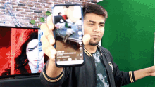 a man is holding up a cellphone with a picture of a woman on it