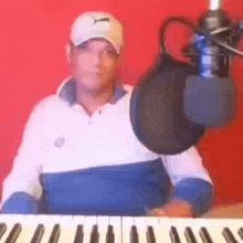 a man is sitting at a keyboard with a microphone .