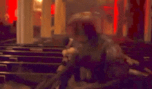 a man in a knight 's armor is standing in front of a church with a red light behind him .