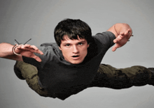 a man in a gray shirt is flying through the air