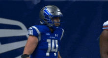 a football player wearing a helmet with the letter m on it is giving another player a high five