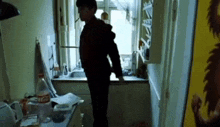 a man is standing in a kitchen with a coca cola bottle in the background .