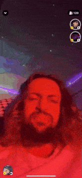 a man with a beard is making a funny face while talking on a video call on his phone .