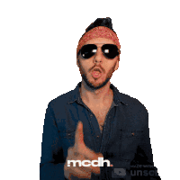a man wearing sunglasses and a bandana is pointing at something