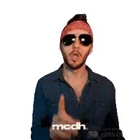 a man wearing sunglasses and a bandana is pointing at something