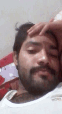 a man with a beard is laying on a bed