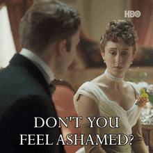 a man in a tuxedo talks to a woman in a white dress who says " don t you feel ashamed "