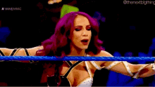a woman with purple hair is in a wrestling ring with a blue rope