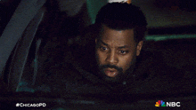a man in a car with #chicagopd on the bottom right